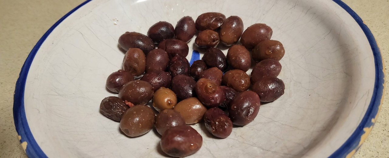 Small dark Cuquillo olives on a plate